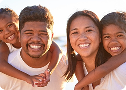 A mom and a dad with their children smiling.